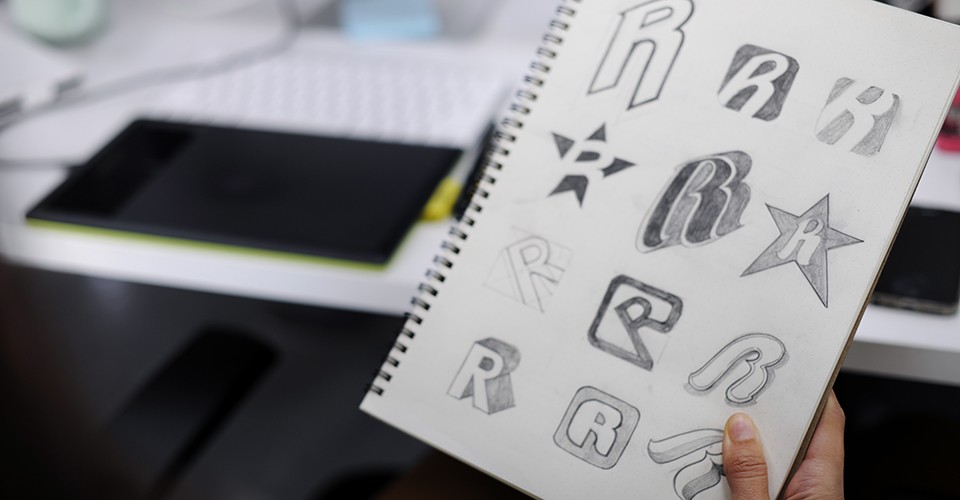Hand Holding Notebook With Drew Brand Logo Creative Design Ideas